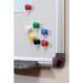 The picture shows a pack of 12 Nobo magnetic drawing pins from ACCO Brands. The pins are in various bright colors and are held in a plastic container. Each pin has a round magnetic top and a sharp metal point for easy insertion into a drawing board or whiteboard. The pins are ideal for holding up important papers, notes, or artwork, making them a useful addition to any home or office space.