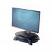 The image shows a graphite-colored rotating monitor riser platform with a weight capacity of 14kg. Fellowes monitor stands and dust covers can also be seen in the background. The sleek design and sturdy construction of the riser offer a stylish and functional addition to any workspace.