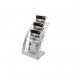 The photograph shows a sleek silver literature holder with three tiers, designed for DL size portraits. The Deflecto logo can be seen on the bottom corner. The holder appears to be sturdy and well-crafted, with clear panels for easy visibility of the literature inside. Perfect for organizing and displaying brochures, pamphlets, and flyers in a professional setting.