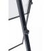 The photo shows a sleek black magnetic flipchart easel, measuring 700x1000mm, paired with a stack of white flipchart pads. The easel has a sturdy footbar for support, and the pads have a Bi-Silque and Bi-Office logo at the top. A hand is seen writing on one of the pages, creating a visual aid for a presentation or brainstorming session. The room is well-lit, with office chairs and a table in the background. The overall image exudes professionalism and efficiency.