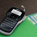 The photo showcases the sleek and convenient design of the Newell Brands Label Makers Dymo LabelManager 280 Handheld Label Printer. Its QWERTY keyboard provides ease in labeling, while the black and silver color combination adds a touch of elegance.