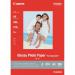 The picture shows a pack of Canon GP-501 A4 glossy photo paper with 100 sheets. The paper has a smooth, shiny finish and comes in a standard A4 size. The packaging displays the Canon brand and product name.