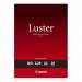 The photograph shows 20 sheets of Canon LU-101 A3 luster paper, designed specifically for Canon photo printers. Each sheet has a glossy finish with vibrant colors, making it perfect for creating high-quality prints.