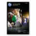 The image is of a pack of 100 HP glossy photo papers, each measuring 10x15cm. The pack is neatly organized and sealed, with the brand name and product name clearly displayed on the front. The papers appear to have a high-quality sheen and smooth surface, perfect for printing vibrant and sharp photos.