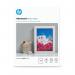 The image shows a pack of glossy white photo paper by HP, measuring 13x18cm, with a total of 25 sheets inside. The paper is advanced and high quality, perfect for printing vibrant and sharp photographs.